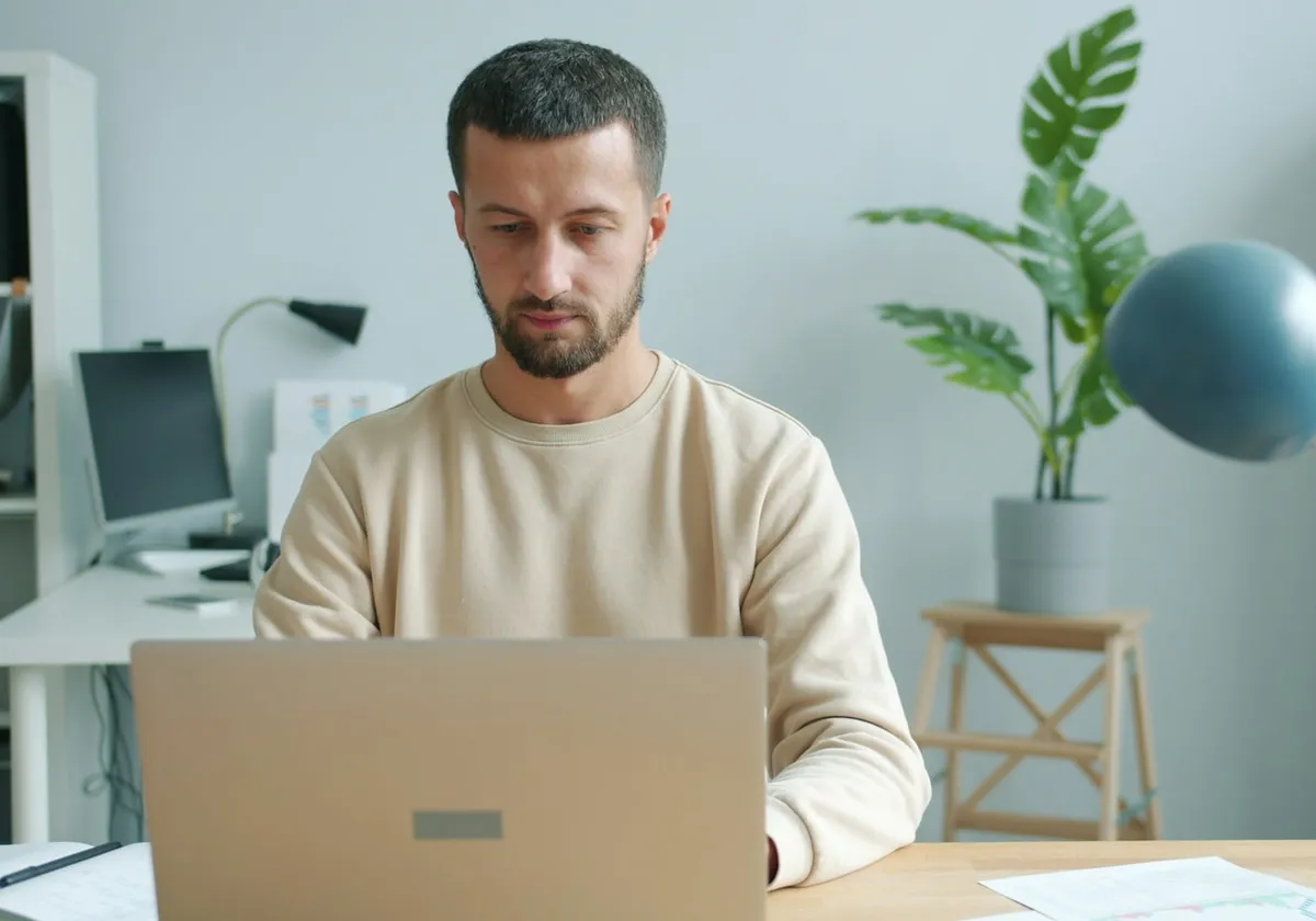 A business owner working intently at a laptop in a calm, modern office