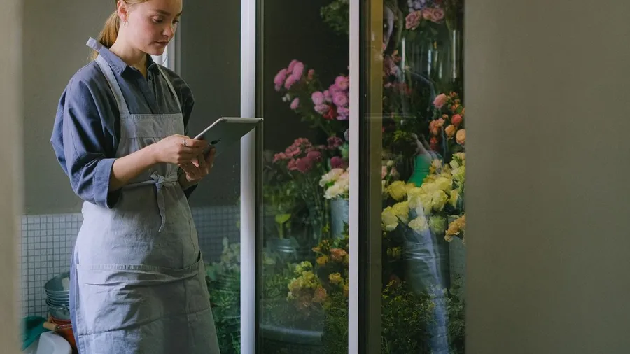 Small business owner in an apron reviewing marketing results on a tablet — what works in small business marketing in 2026