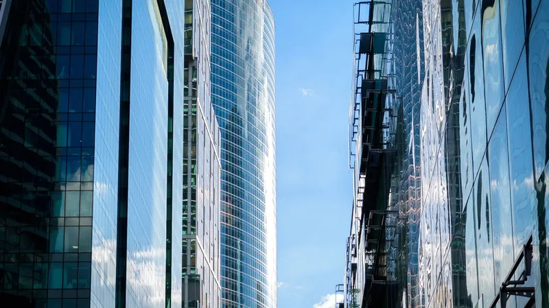 Looking up at towering glass corporate skyscrapers, representing the big marketing agency holding companies built for global enterprise brands