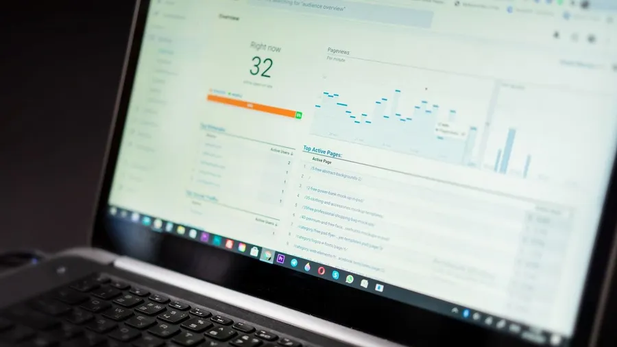 A laptop screen showing a real-time web analytics dashboard with active users and traffic charts — the growth a done-for-you marketing service drives for a SaaS product