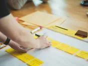 A marketer mapping out a strategy with sticky notes and markers on a large sheet of paper — the strategic planning a fractional CMO delivers