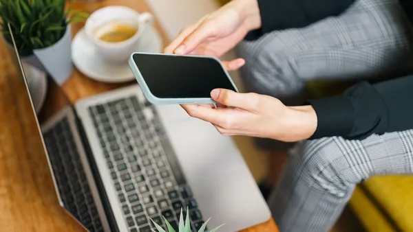 Small business owner checking search rankings and an AI chatbot answer side by side on a laptop — is SEO dead or just split in two