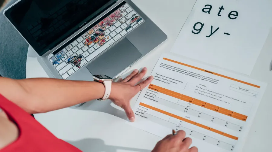 Small business owner reviewing a managed marketing pricing breakdown on a laptop at a desk