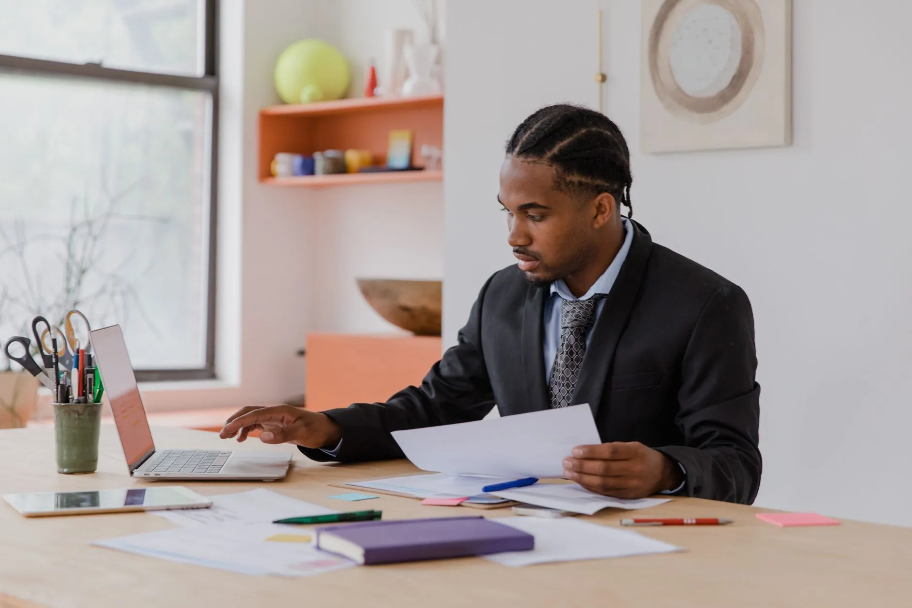 Business owner reviewing documents and planning at a modern office desk
