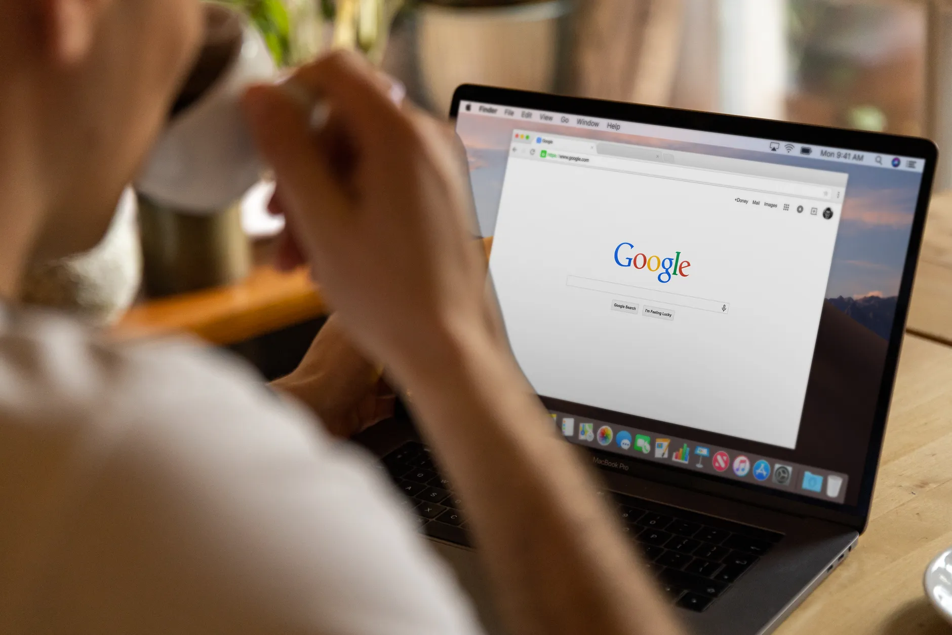 Person browsing the web on a laptop at a desk, tracking SEO and organic search progress over time