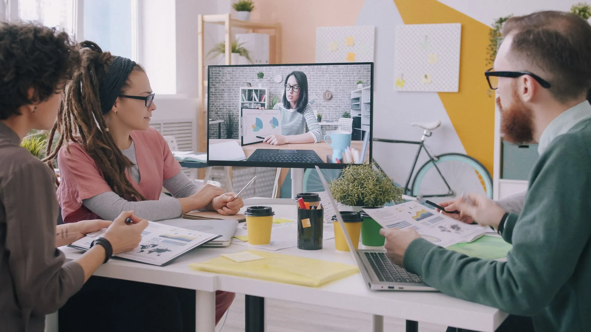 Creative team in a modern office engaged in a video conference, showing how a managed service team collaborates with your business remotely