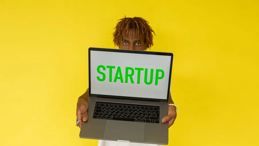 A SaaS founder working on their laptop reviewing marketing strategy and growth charts for their startup