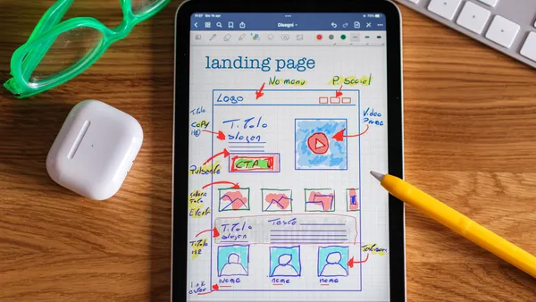 Small business owner comparing website pricing plans on a laptop at a desk, weighing DIY builder, freelancer, agency, and managed website costs